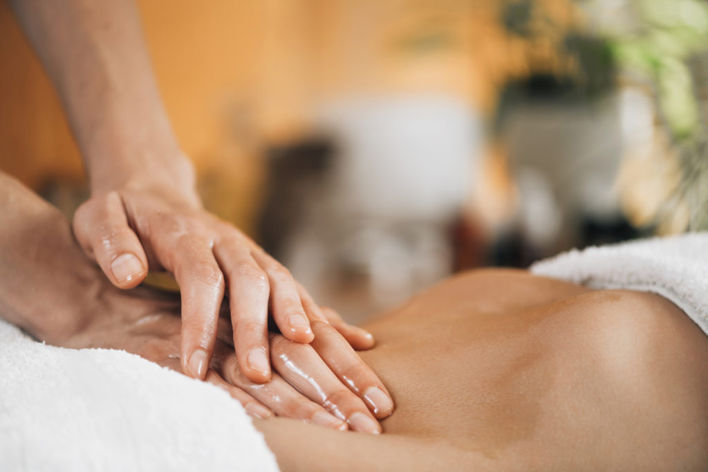 woman in towel receiving stomach massage